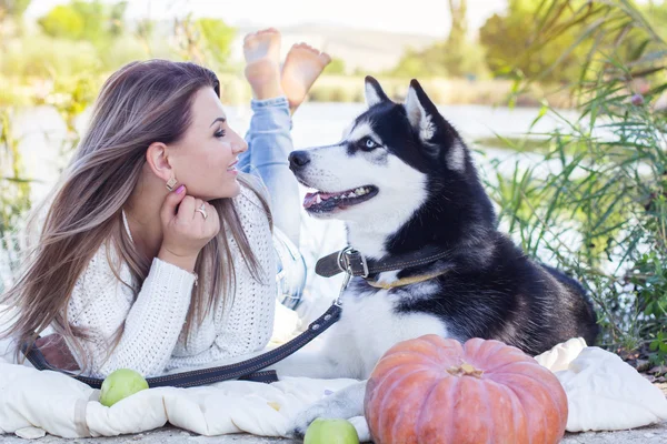 Fille et son chien husky est couché près de la rivière — Photo