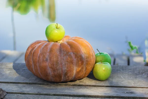 Pumpkin and green apples in autumn outdoors — Stock Photo, Image