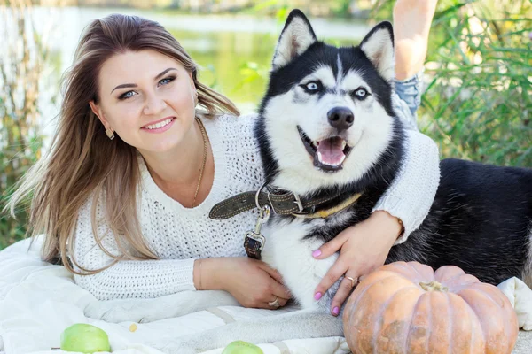 Happy girl is hugging her husky dog outdoors — Stock Photo, Image