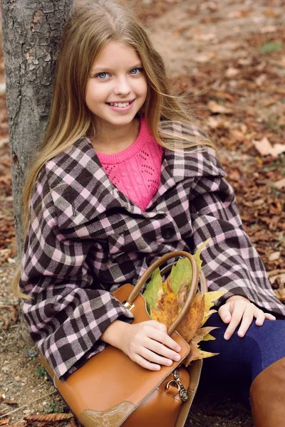 Linda chica sonriente con bolsa llena de hojas de arce —  Fotos de Stock