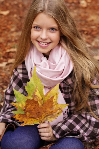 단풍나무와 귀여운 웃는 소녀 손에 나뭇잎 — 스톡 사진