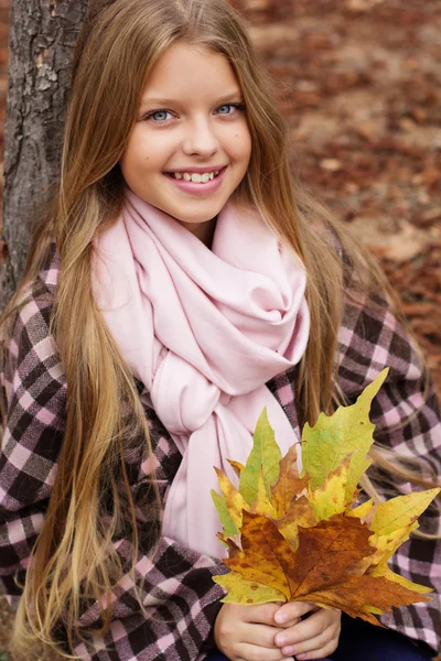 Красивая улыбающаяся девушка с кленовыми листьями в руках — стоковое фото