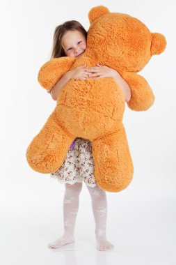 Kız çocuk oyuncak ayı kucaklayan