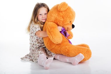 Kız çocuk oyuncak ayısının tutuyor