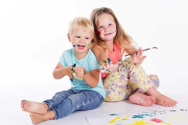 Två barn ritar av aquarelle färger Stockbild