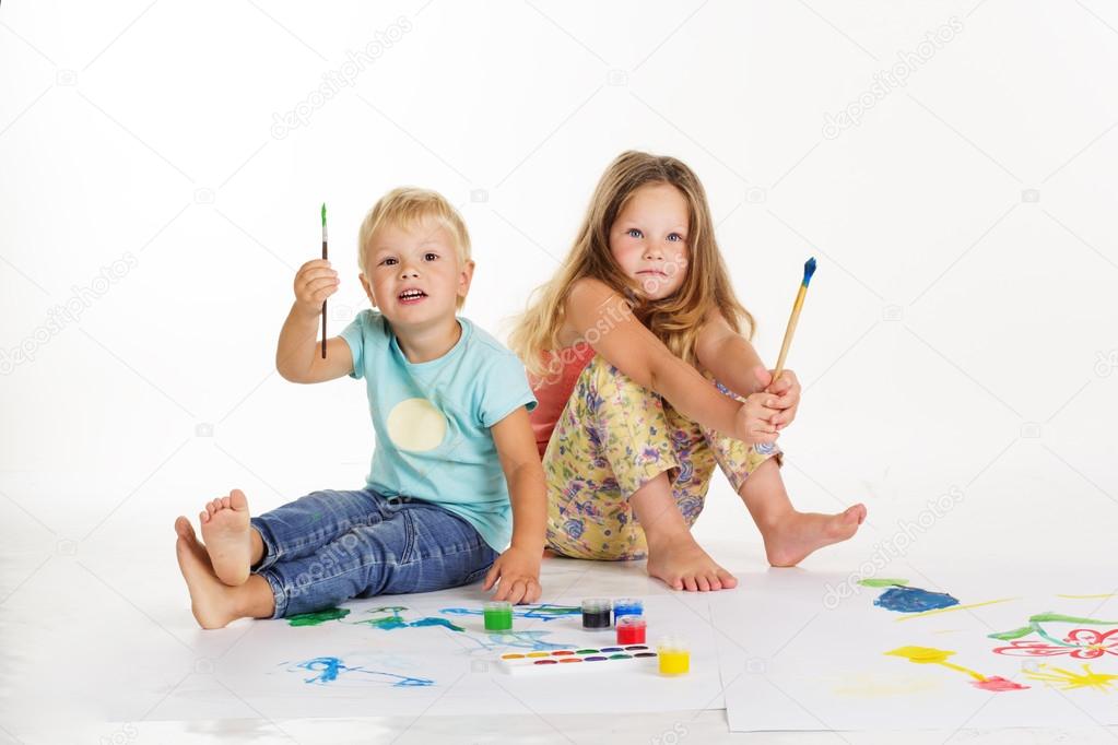 Boy and girl are drawing pictures by paints