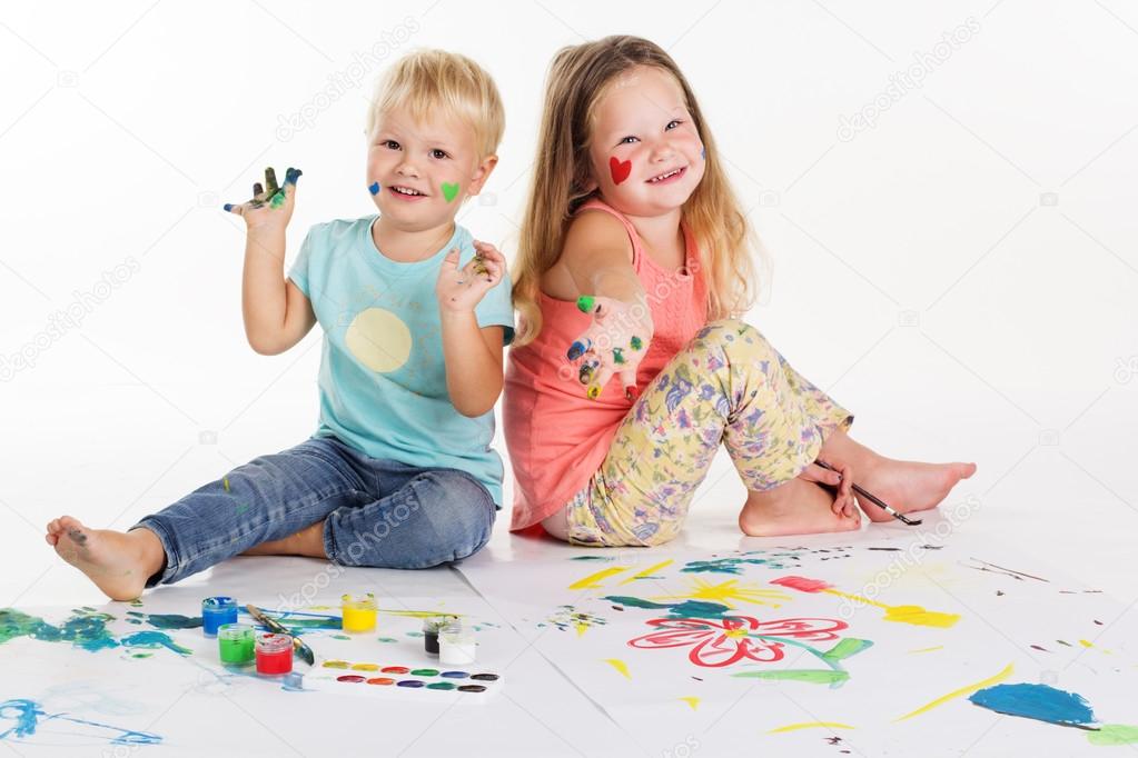 Childs are drawing pictures by aquarelle paints