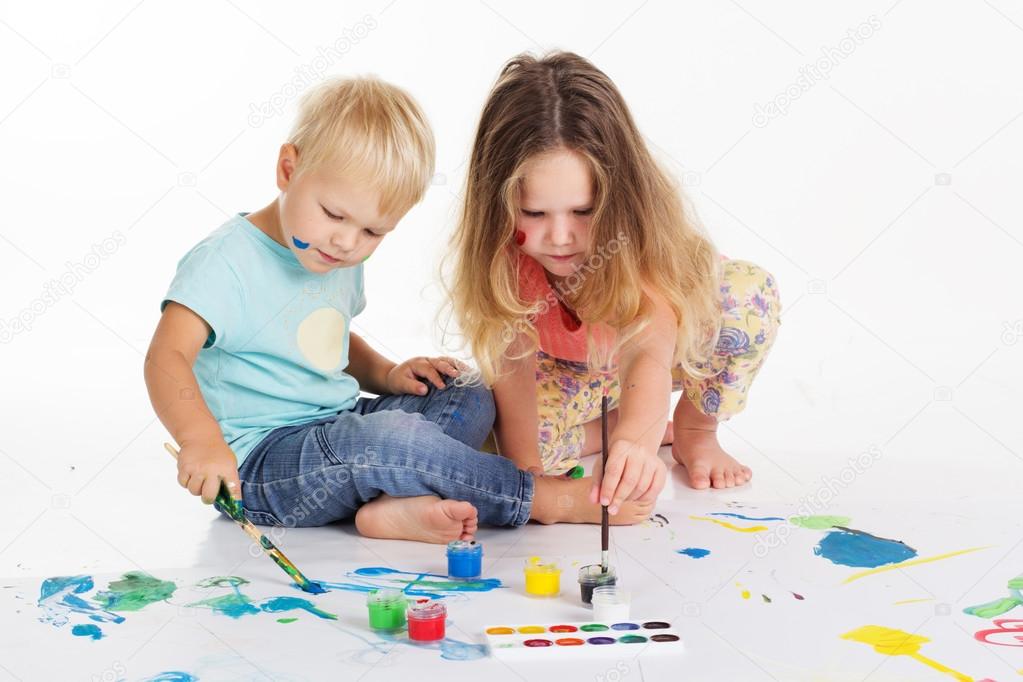 Childs are drawing pictures by aquarelle paints