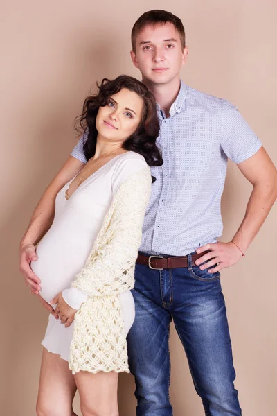 Lyckliga paret är väntande baby poserar i studio — Stockfoto