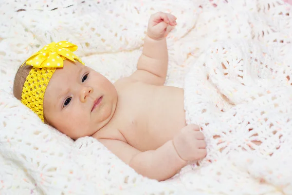 Two month baby girl with yellow ribbon on head — Stock Photo, Image