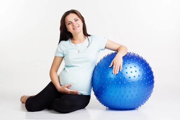 Беременная женщина занимается фитнесом с мячом — стоковое фото