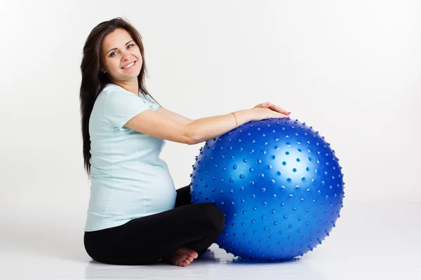Mujer embarazada haciendo ejercicio físico con bola azul —  Fotos de Stock