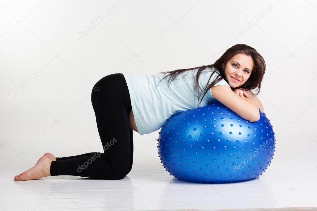 Pregnant girl exercising pilates with fitball