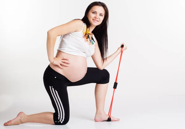 Mujer embarazada haciendo ejercicios con banda de resistencia —  Fotos de Stock