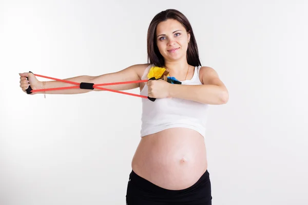 Pregnant pretty woman doing sport with resistance band — Stock Photo, Image