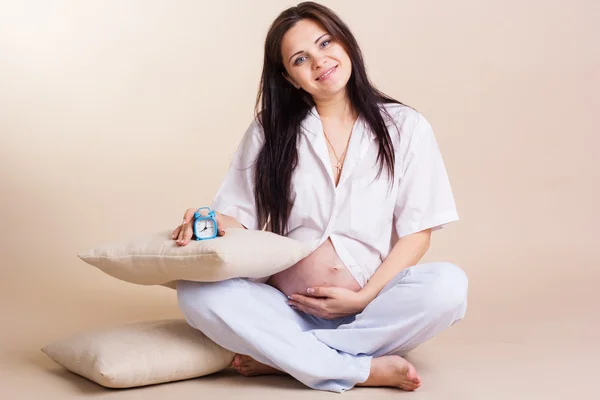 Беременная женщина держит живот в белой рубашке — стоковое фото