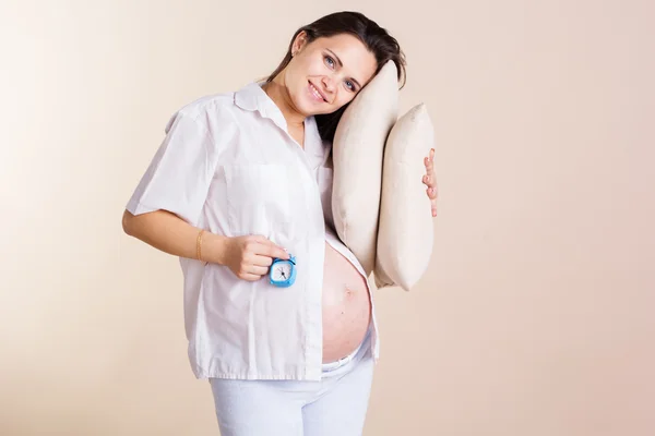 Pregnant woman is wearing pajamas holding pillows — Stock Photo, Image