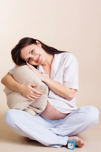 Mujer embarazada está sentada con almohadas — Foto de Stock