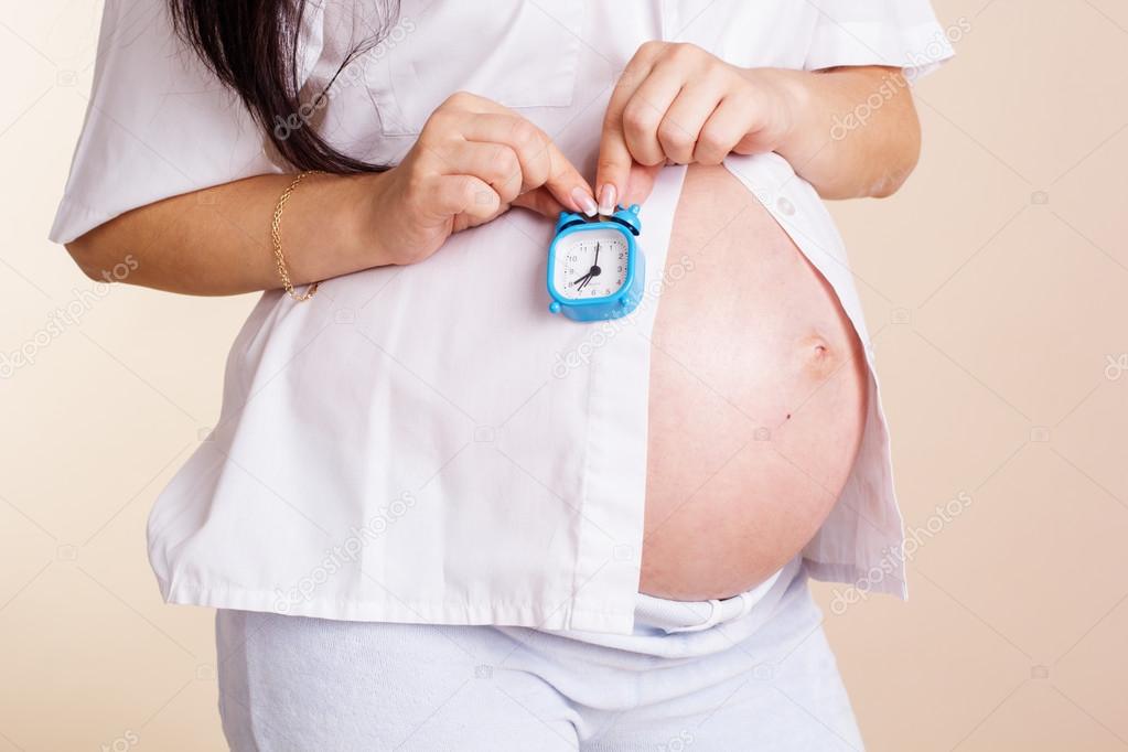 Belly of pregnant woman with watches
