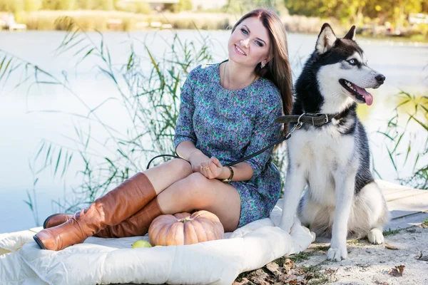 Jeune femme et grand chien husky se repose à l'extérieur — Photo