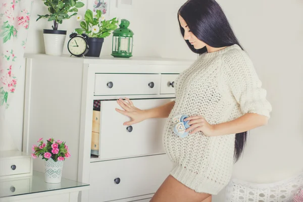 Chica embarazada en casa está usando suéter — Foto de Stock