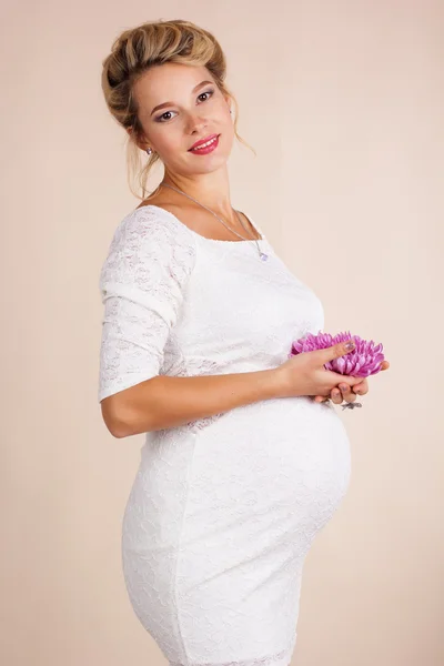 Беременная женщина с розовым цветком — стоковое фото