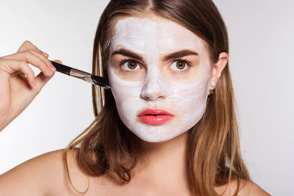 Bella ragazza applicazione di argilla bianca maschera facciale — Foto Stock
