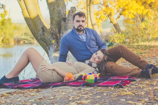 Happy young couple on the picnic in autumn park — Stock Photo, Image