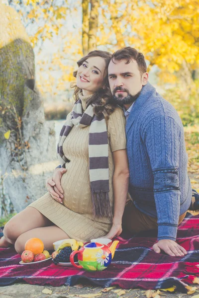 Heureux couple de futurs parents se reposent près du lac — Photo