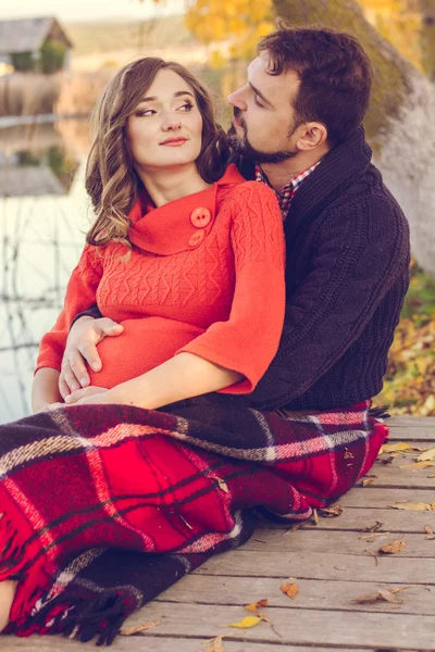 Беременная девушка и мужчина завернуты в теплое одеяло — стоковое фото