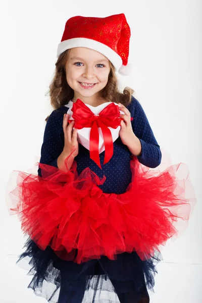 Child girl is holding gift box with red ribbon — Stock Photo, Image