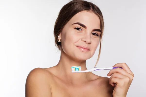 十代の少女は、歯磨き粉で歯ブラシを保持しています。 — ストック写真