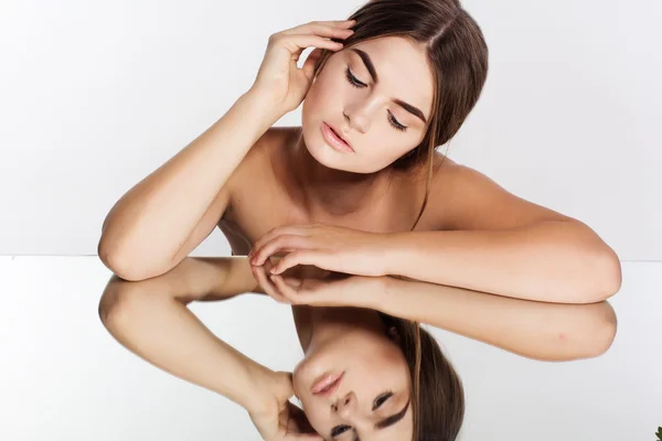 Mooi meisje en haar reflectie in de spiegel — Stockfoto