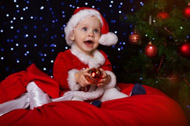 Köknar ağacı yakınındaki kırmızı Noel top ile mutlu bebek