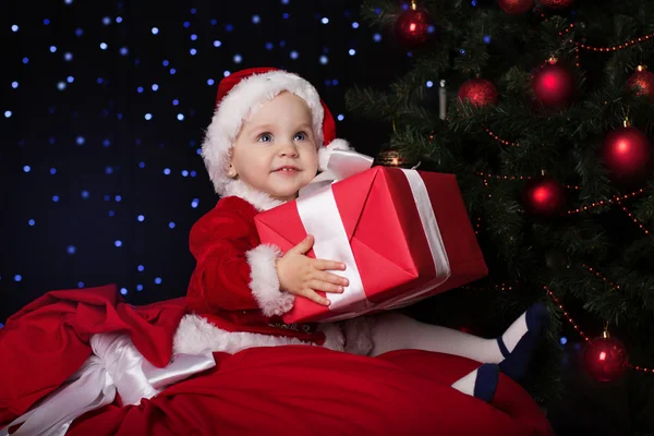 Baby in a Christmas santa costume with gift — Stock Photo, Image