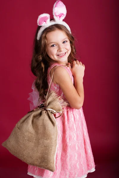 Child girl with gift bag is wearing bunny ears — Stock Photo, Image