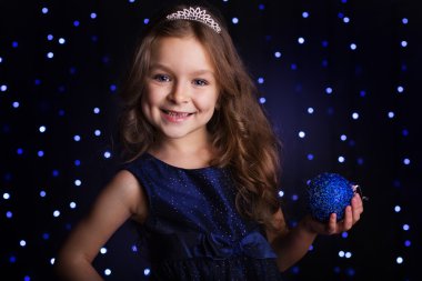 Pretty girl is holding blue christmas ball