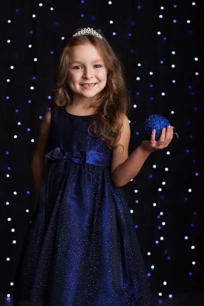 Pretty child girl is holding blue christmas ball — Stock Photo, Image