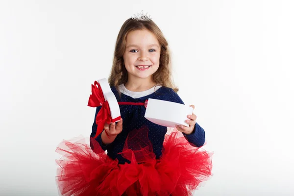 Happy girl is holding gift box with red ribbon — Stock Photo, Image