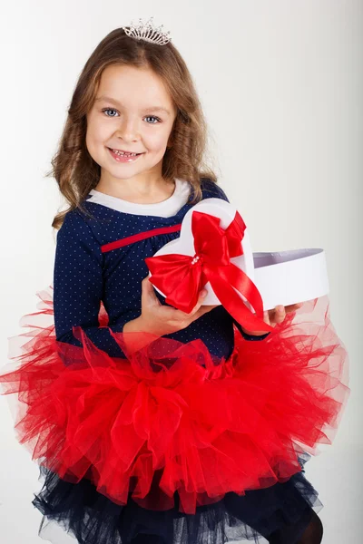 Pretty girl is holding gift box with red ribbon — Stock Photo, Image