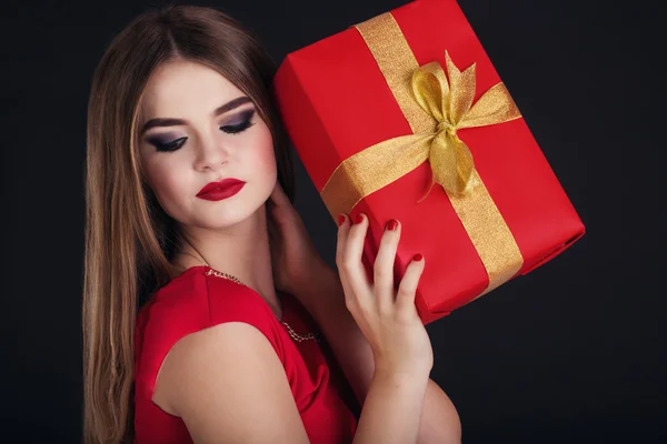 Pretty girl is holding gift box, Christmas time — Stok fotoğraf