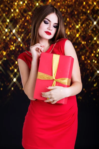 Menina bonita está vestindo vestido vermelho com caixa de presente — Fotografia de Stock