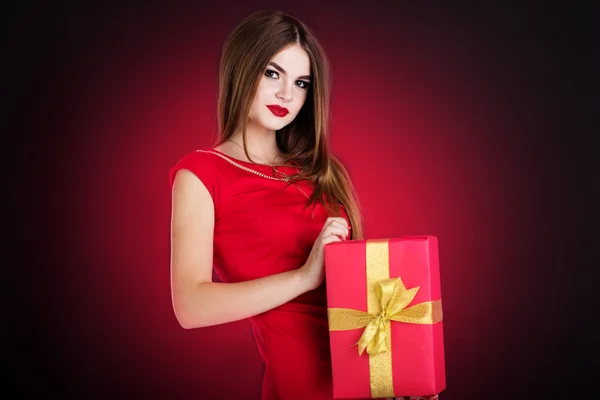 Pretty girl is holding red gift box — Stock Photo, Image