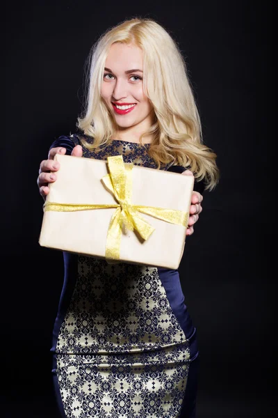 Gülümseyen kadın hediye kutusu ile kurdele tutuyor