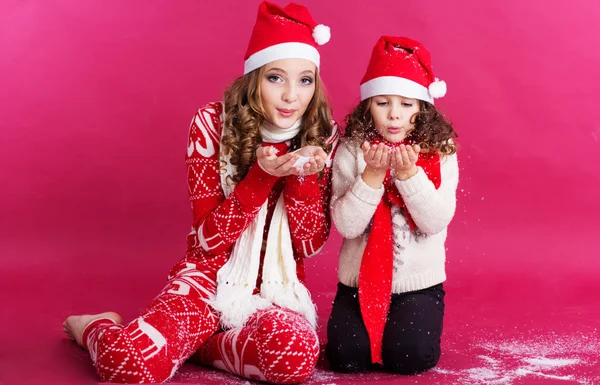 Dos chicas guapas están usando ropa de estilo navideño en el estudio —  Fotos de Stock