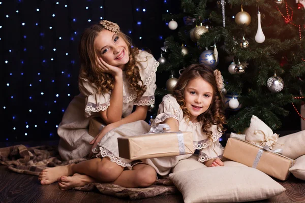 Two sisters with christmas gifts at home — Stock Photo, Image