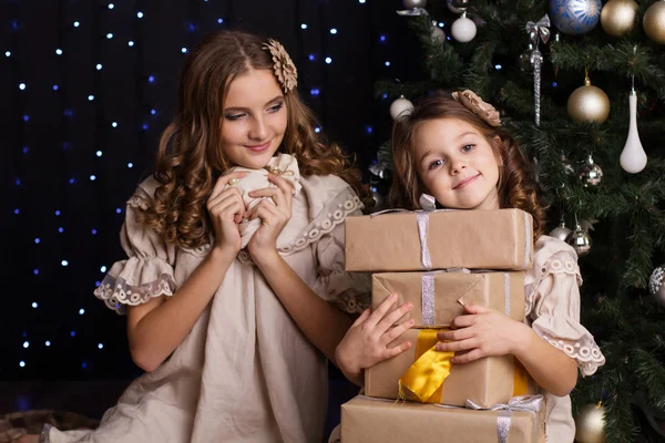 Deux filles amies avec des cadeaux près de l'arbre de Noël — Photo