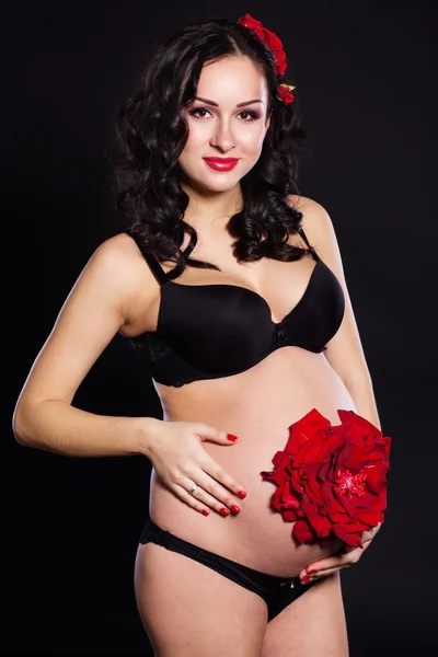 Fille enceinte avec fleur rose rouge sur le ventre — Photo