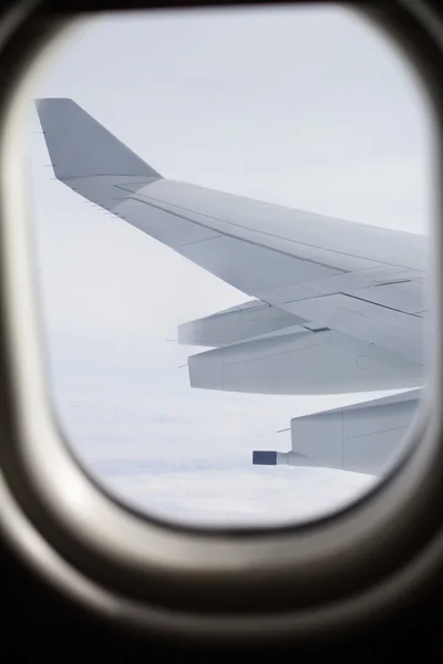 Ala de un avión volando desde el ojo de buey —  Fotos de Stock