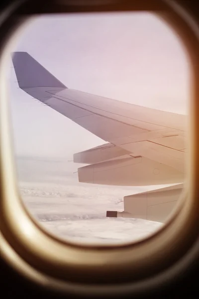 Vista de un ala de avión volando desde el ojo de buey —  Fotos de Stock